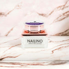 NAILINO Glitzer Farbgel Lavender Radiance für elegante Gelnägel in einem stilvollen Glasbehälter auf marmoriertem Hintergrund