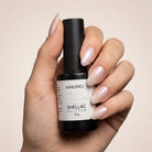 NAILINO Shellac Pearl Champagne - Shellac Rosé Perlmutt Glitzer in einer Hand mit glitzernden Nägeln.