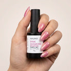 NAILINO Shellac Pink Diamond Gel in einer Hand mit glitzernden rosa Nägeln.