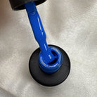 NAILINO Shellac Royal Azure bottle with bright royal blue nail polish pouring out.