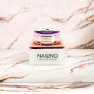 NAILINO Glitzer Farbgel Stardust Dreams im eleganten Behälter für funkelnd lila Gelnägel auf weißem Hintergrund